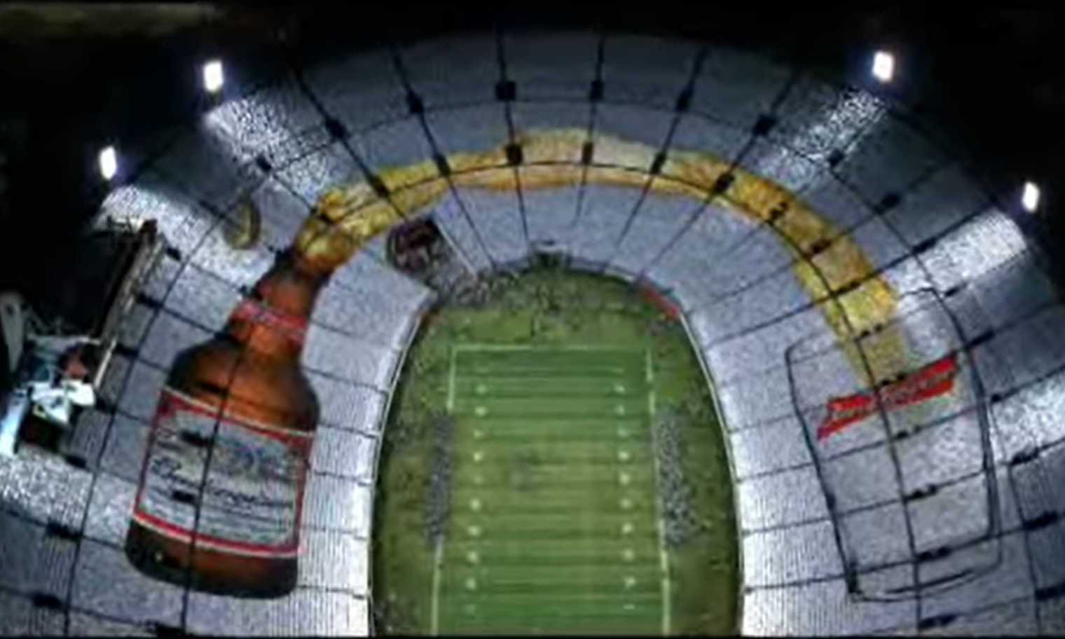 Geprojecteerde bierfles en glas op stadionstoelen tijdens voetbalwedstrijd.