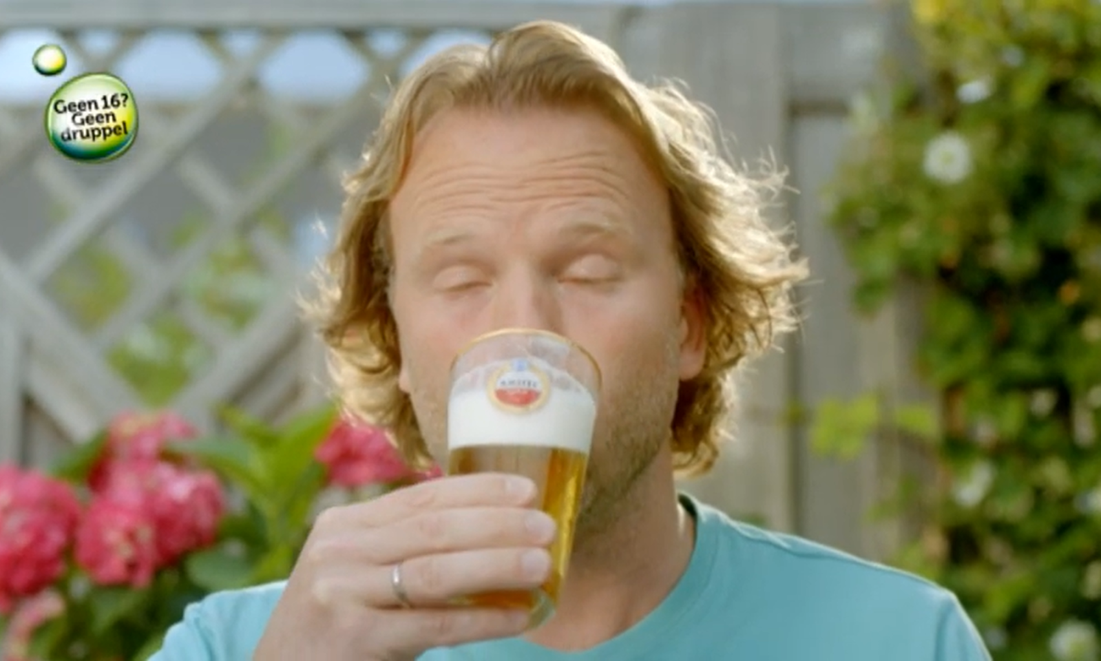 Man sluit ogen terwijl hij bier drinkt in de tuin.