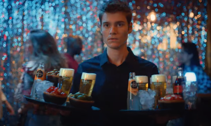 Barman met twee dienbladen met drankjes en bier Barman met twee dienbladen met drankjes en bier